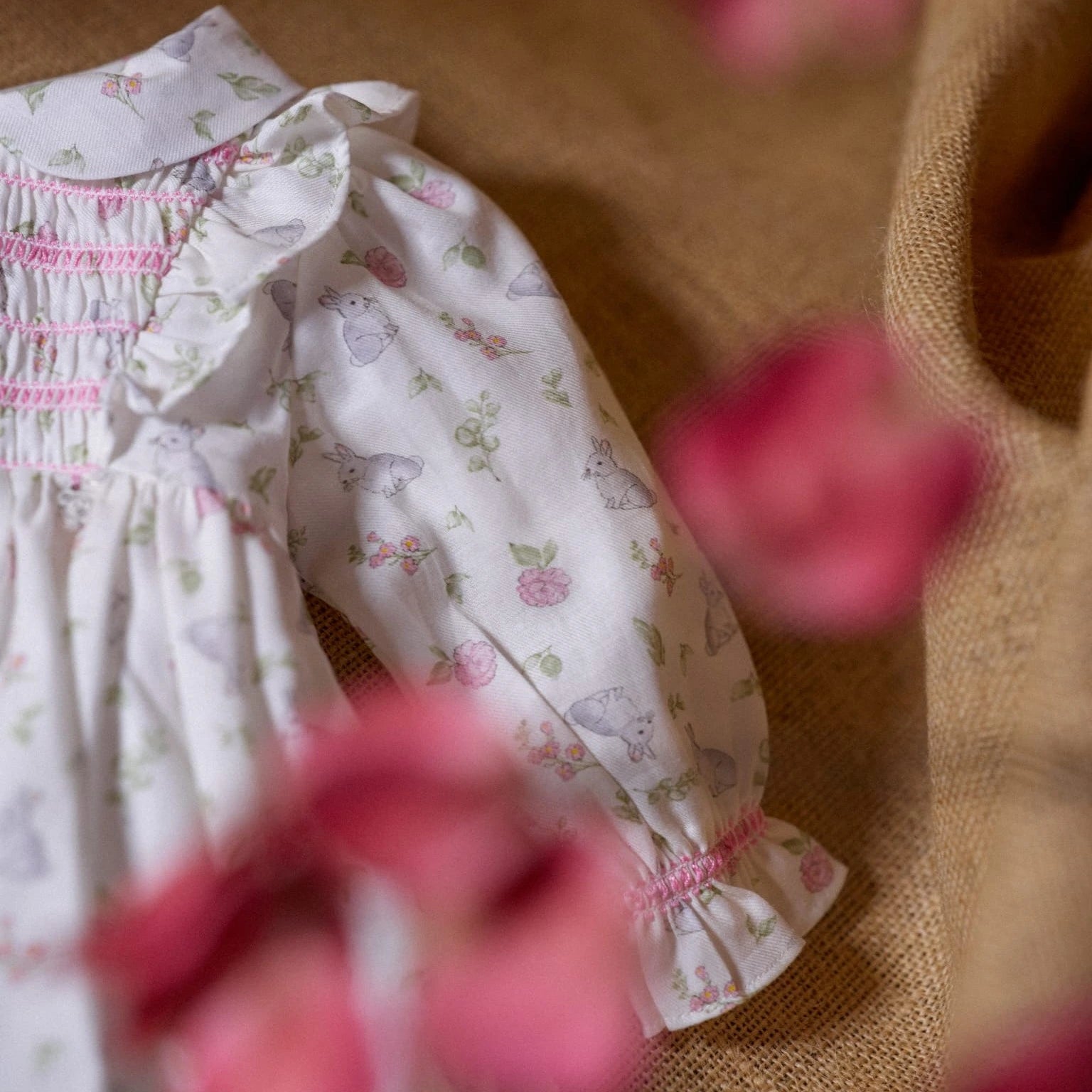 Floral dress with pink embroidery on a textured surface