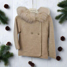 Beige knitted jacket with fur hood on a white background