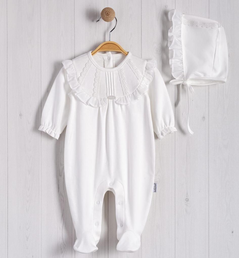 White baby romper with ruffled collar and matching bonnet on a wooden hanger against a light wooden panel background.