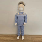 Mannequin wearing a blue sweater and pants set with a patterned collar against a plain background