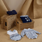Wicker baskets with baby clothes on a beige background