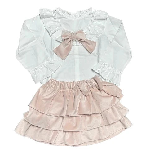 White blouse with ruffled sleeves and a pink bow, paired with a pink ruffled skirt on a white background.
