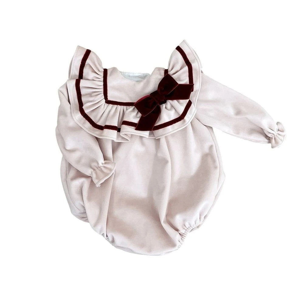 White baby romper with a brown bow on a white background