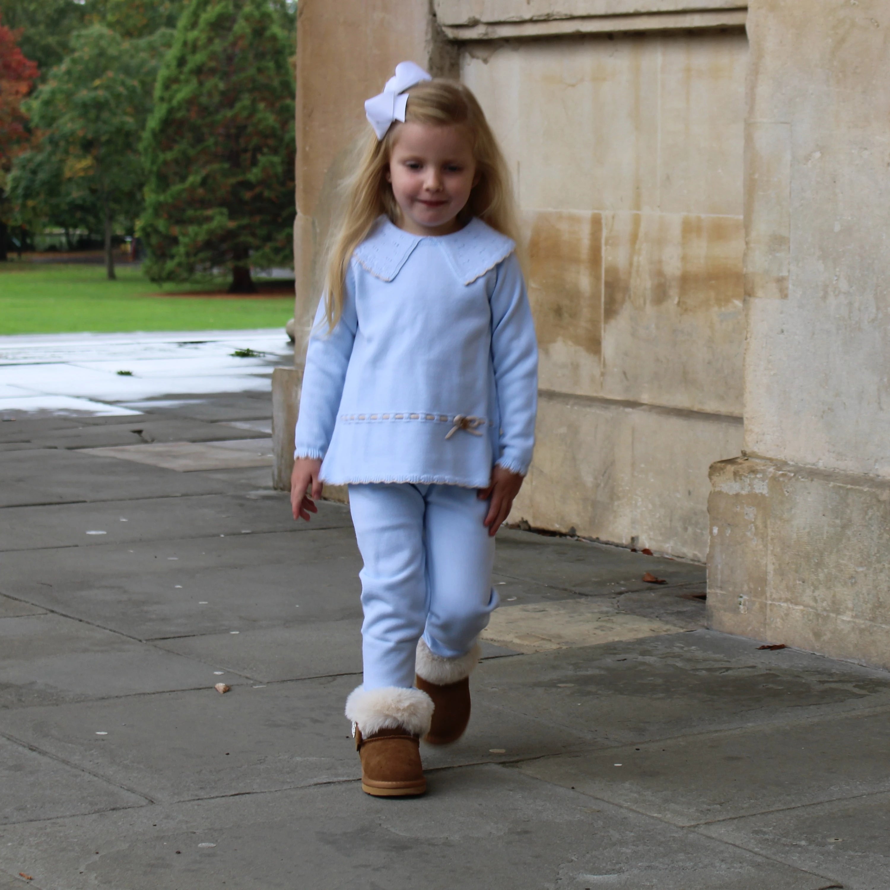young girl wearing a soft blue knit tracksuit