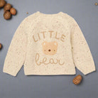 Beige knitted sweater with 'Little Bear' text and bear graphic on a white background