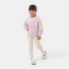 Young girl wearing a pink sweater with a bow design on a white background