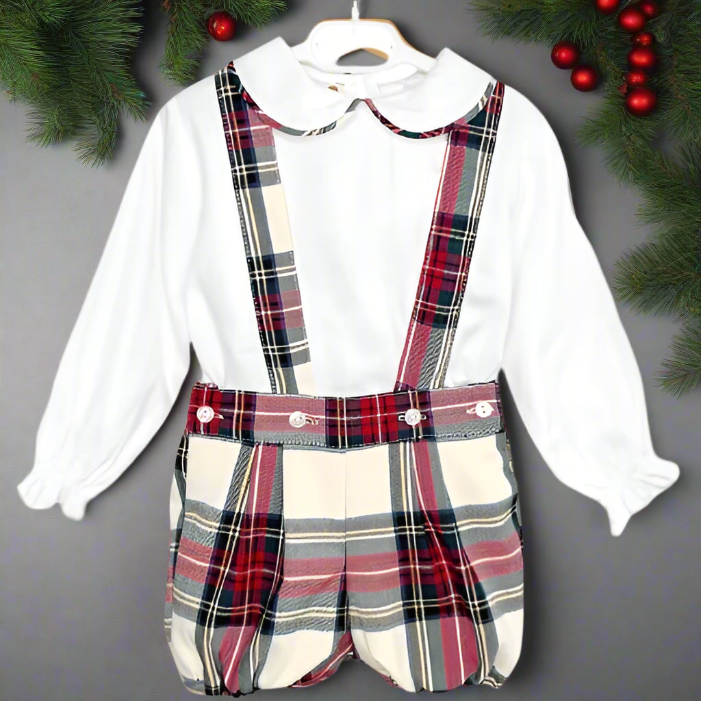 A boys' noel set consisting of a white woven shirt with red, green, and ivory tartan piping on the collar and matching tartan jam pants with braces.