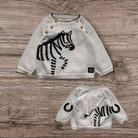 Children's sweater with zebra design on a wooden surface