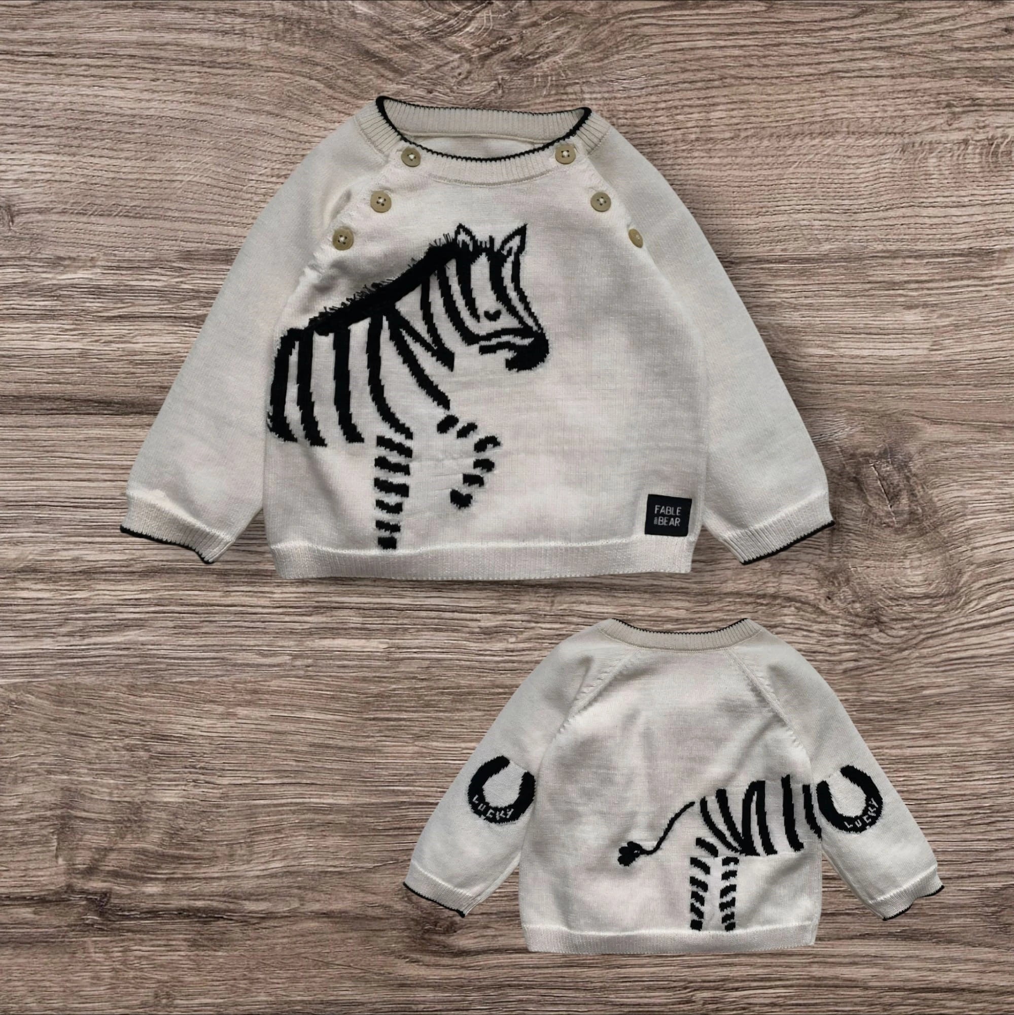 Children's sweater with zebra design on a wooden surface