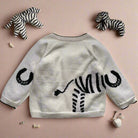 White sweater with black tiger design on a light gray background